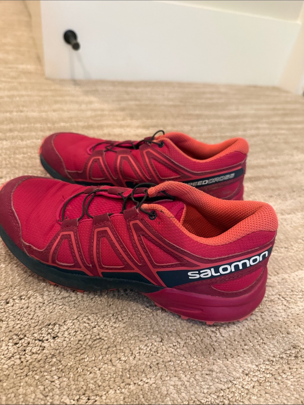 Salomon trail running shoes in pink and coral
